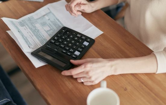 Una mujer con una calculadora y el recibo de la luz / PEXELS Una mujer con una calculadora y el recibo de la luz / PEXELS