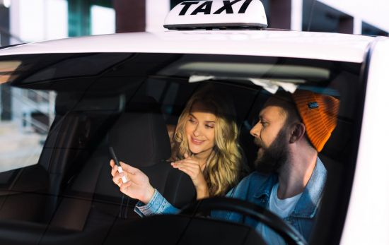 Un conductor de un taxi con una cliente / VASCOELECTRONICS Un conductor de un taxi con una cliente / VASCOELECTRONICS
